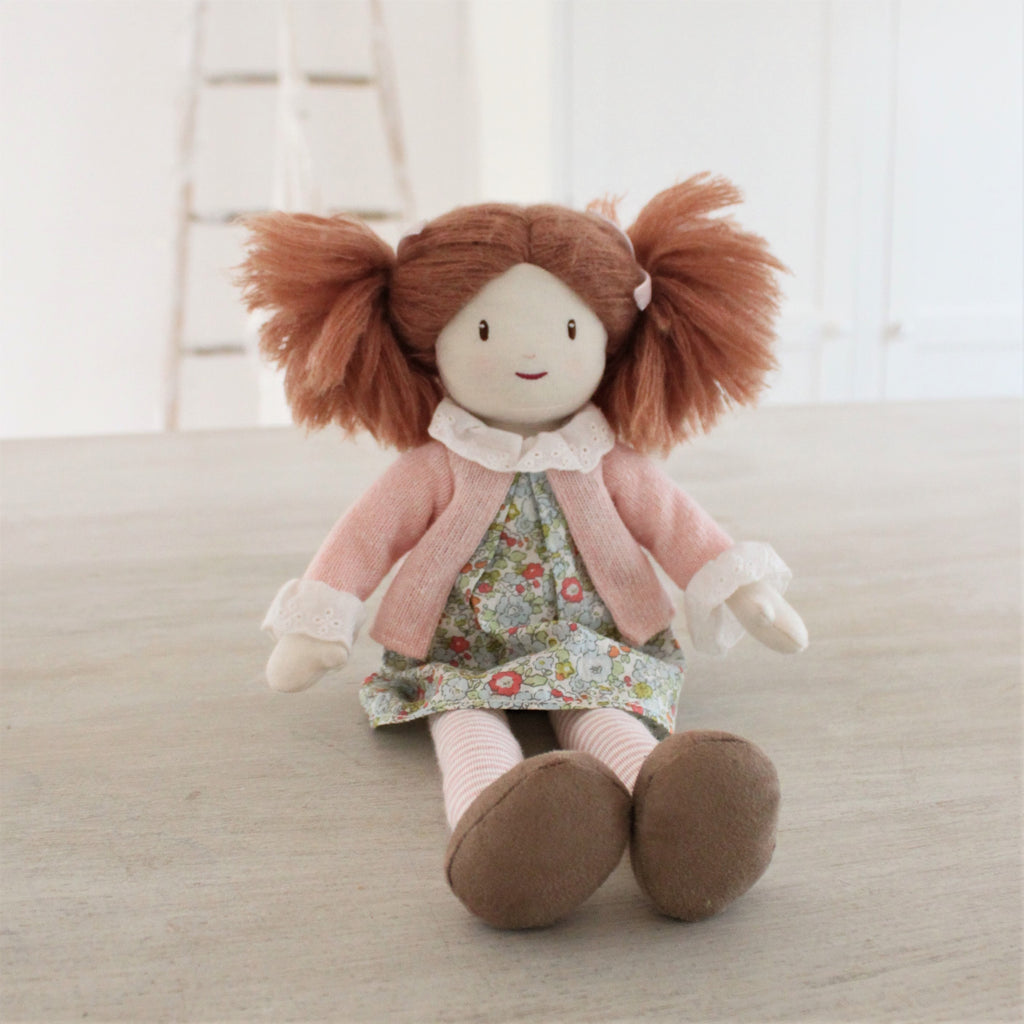 plastic-free rag soft doll with bunches and floral dress with pink cardigan